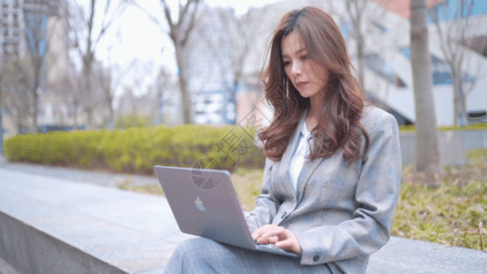操作笔记本职场女性坐在台阶上办公GIF高清图片