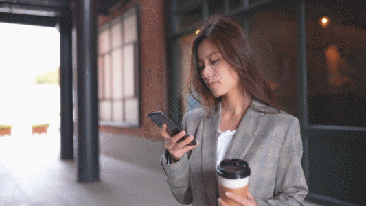 女生在玩手机喝咖啡GIF图片