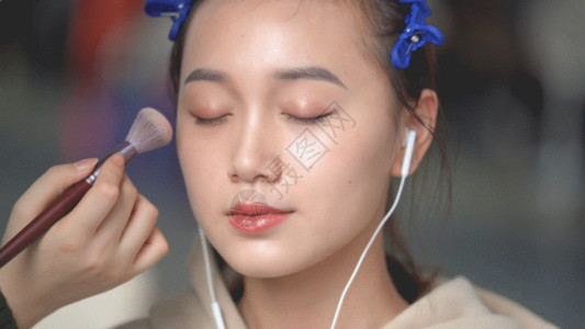 耳机女孩化妆师给模特化妆GIF高清图片