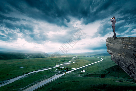 站在岩石上眺望未来的商务人士设计图片