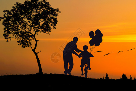 男孩放飞气球父子夕阳剪影设计图片
