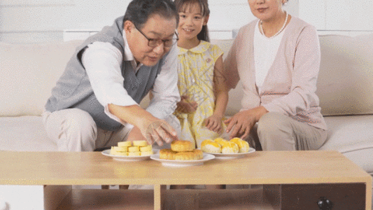 中秋节爷爷奶奶和孙女在家吃月饼GIF图片