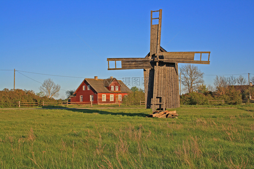 风车停在绿草地上蓝天和农舍背景在爱沙尼图片