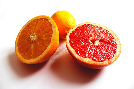 橙色葡萄柚和柠檬的图像分成两半图片