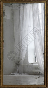 旧镜子中带窗帘的窗户的倒影图片