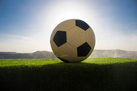 足球场上的足球绿草上的足球阳光明媚的背景图片