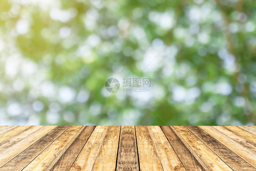 以清晨背景中模糊的抽象绿色布OKh为顶端的木质表用于对产品显示或设计图片
