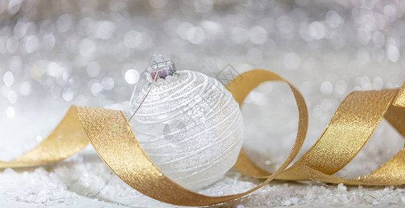 圣诞白球金丝带和雪抽象bokeh灯图片