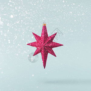 圣诞节的概念创造圣诞节概念由落入空气中的红色明亮的星在蓝色背景图片