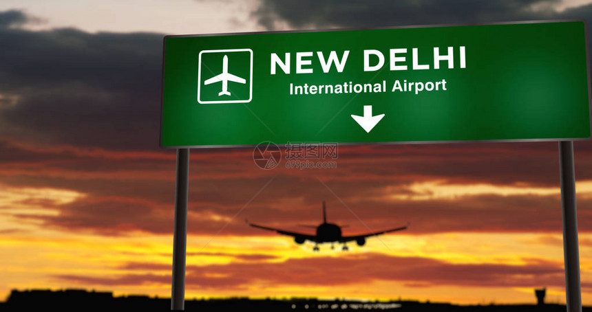 飞机剪影降落在印度新德里与机场方向牌和日落的城市到达在背景中旅行和运输概念图片