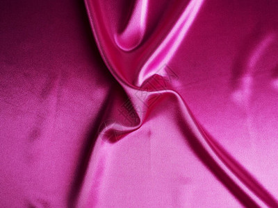 光滑优雅的粉红色丝绸可以用作背景抽象的粉红色丝绸带褶皱的背景图片