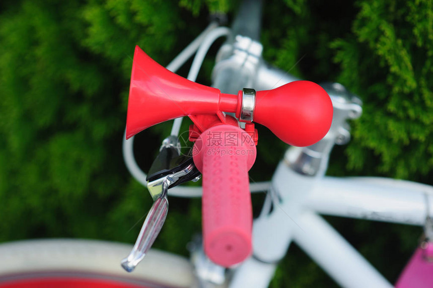 自行车上的蜂鸣器复古风格的红色在一辆白色的自行车上行人安全和警告概念红喇叭图片