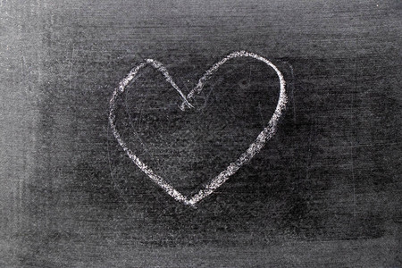 黑板背景上的心形白色粉笔手绘图片