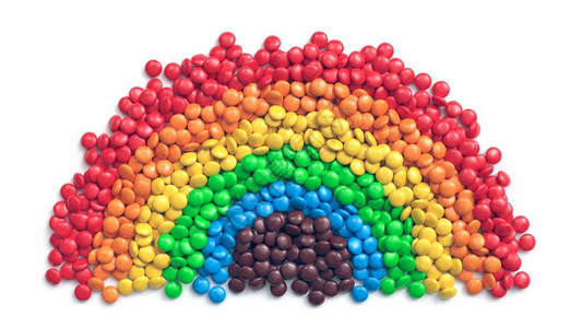 以白色背景彩虹形式排列的多彩涂层巧克力糖果背景图片