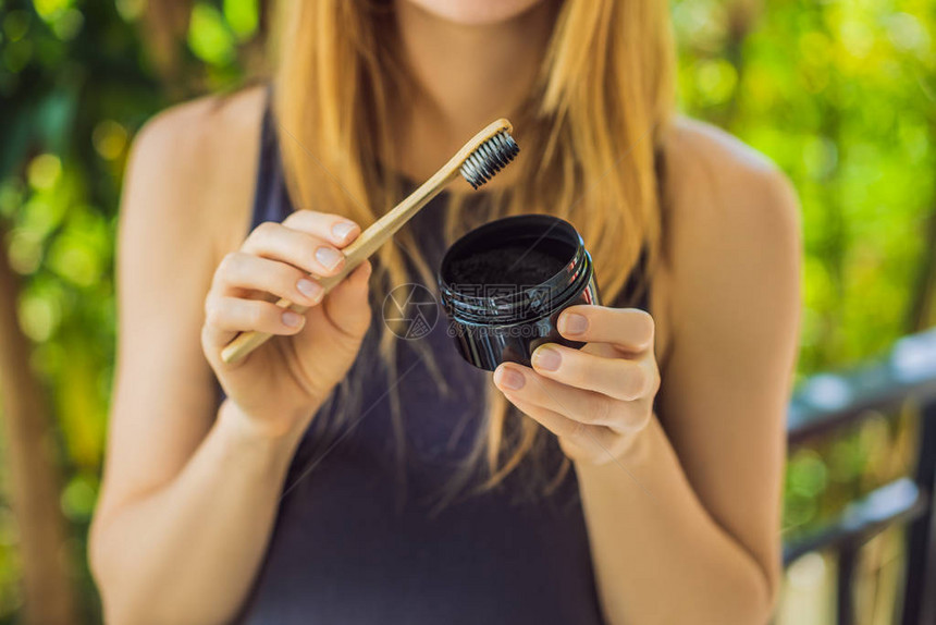 年轻女子刷牙使用活炭粉刷牙和美白牙图片