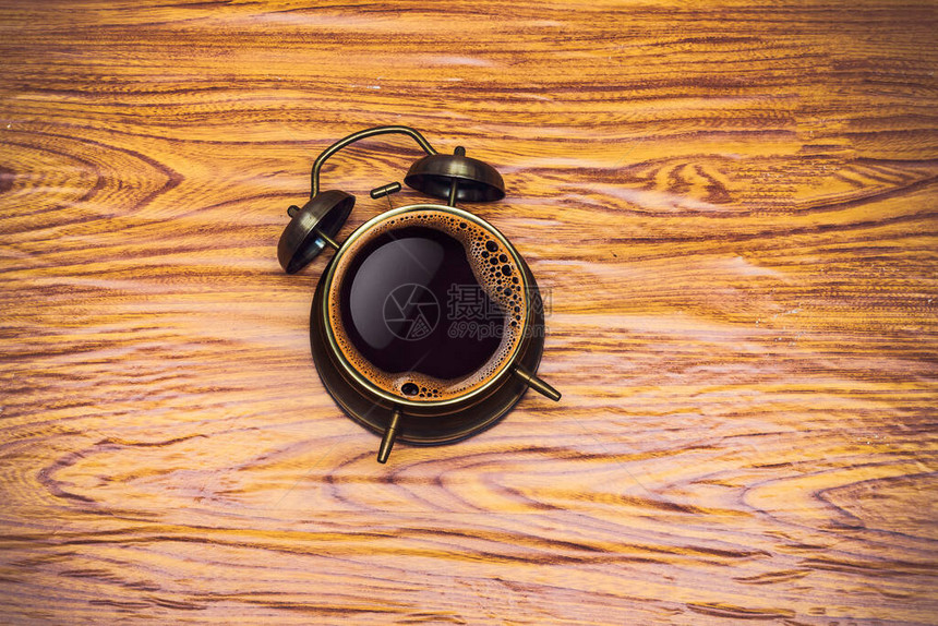 木桌上的闹钟和咖啡概念图片