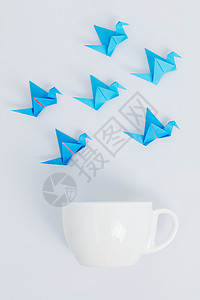 千纸鹤流苏蓝色千纸鹤咖啡杯创意设计背景