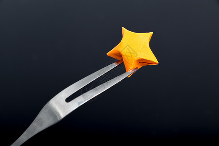 橙色纸质星星黑色背景叉子背景图片
