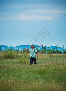 清晨农夫在山下田地草地劳动高清图片