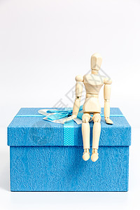 蓝色生日礼盒蓝色礼物盒与木制人偶背景