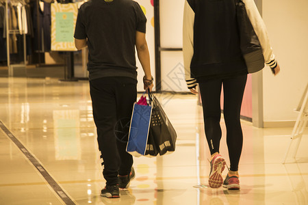 商场里手提购物袋的情侣图片
