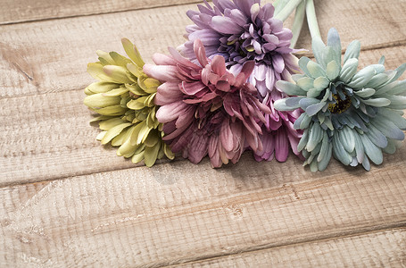 紫色仿真花花束放在木板上的仿真花素材背景