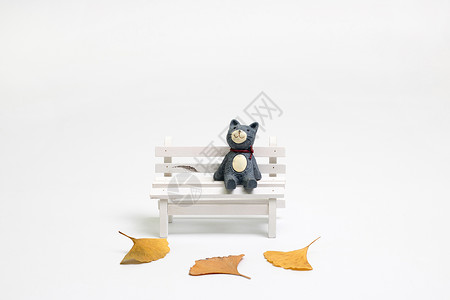 熊带耳机素材坐在枫叶里的玩偶背景