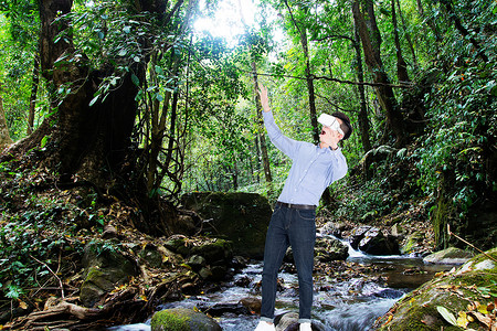 人与森林双手扶VR眼镜和森林环境背景设计图片