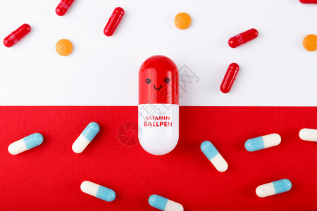 红色胶囊药各种颜色彩色的药片和胶囊背景