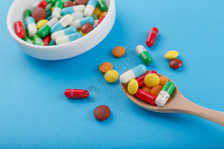 勺子药各种颜色彩色的药片和胶囊背景