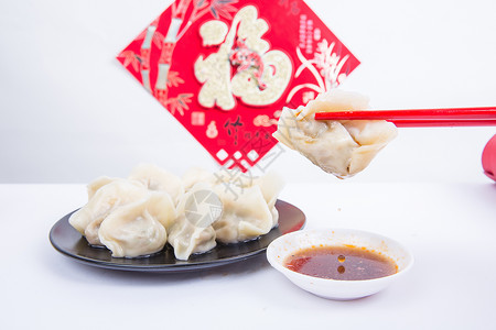 福字为背景的人夹饺子吃的冬至新春节日背景图片