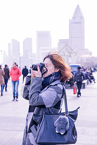 城市街头女性摄影师在拍照图片