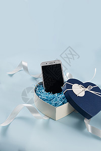 温馨小元素情人节爱心礼盒缎带手机在浅蓝色背景上背景