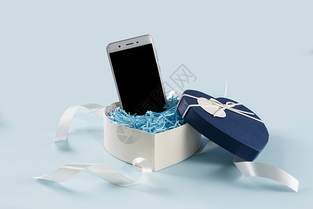 联系科技情人节爱心礼盒缎带手机在浅蓝色背景上背景