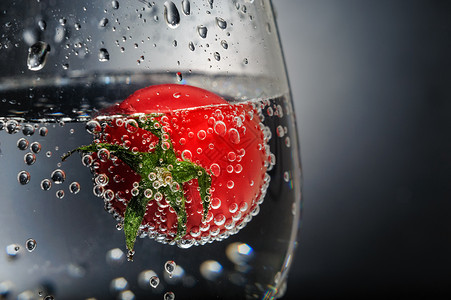 咖灰酒杯中带泡泡的番茄背景