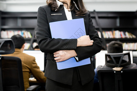 黑色办公桌抱着文件夹的职业女性背景