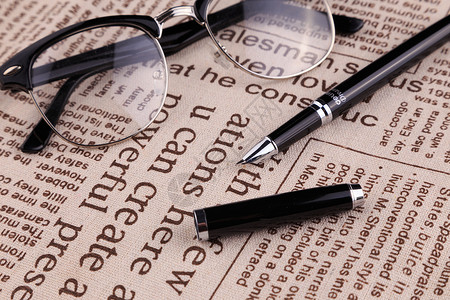 护照和英文报纸眼镜钢笔和报纸背景