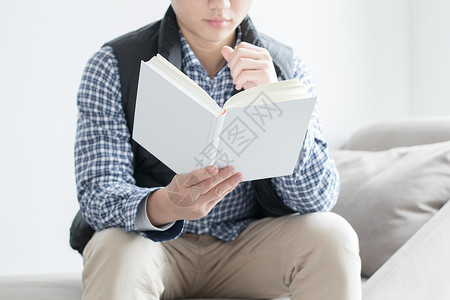 男人的世界坐在沙发上看书的年轻人背景