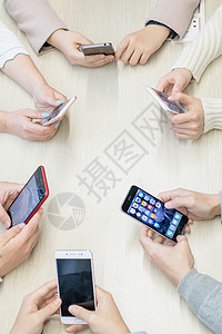 商务聚会桌上围成一圈的手机背景