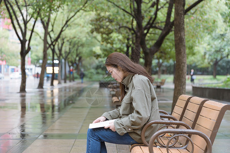 公园里坐着看书的女孩背景图片
