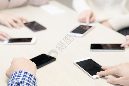 商务聚会桌上围成一圈的手机背景