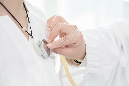 医生用听诊器为病人检查背景图片