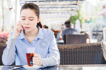 坐着喝茶的女孩年轻女性在咖啡店打电话背景