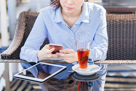 年轻女性户外使用手机休闲放松高清图片