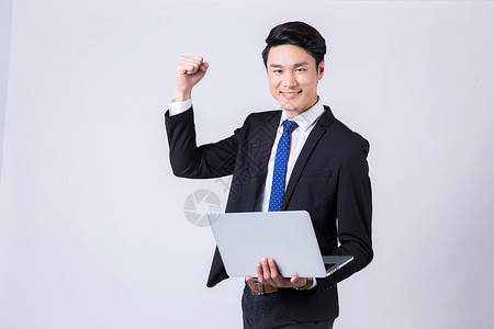 人微笑商务男士拿着电脑庆祝成功背景