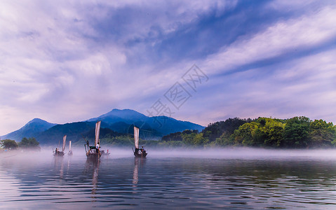 江雾江面行驶的帆船背景