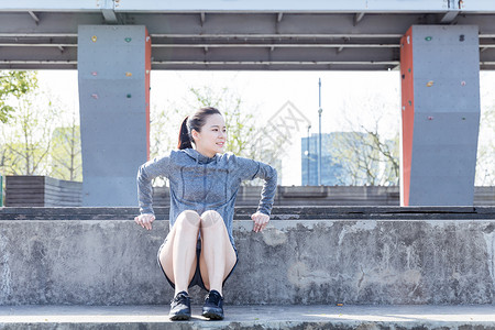 运动女孩支撑石凳压身体背景图片
