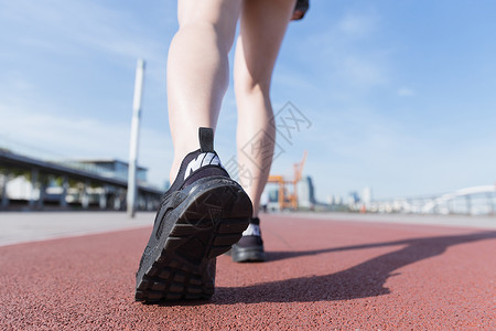 百米训练阳光下运动女孩跑道上走路背景
