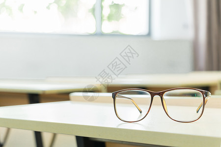 教室里书桌上的眼镜特写教室图片高清图片素材