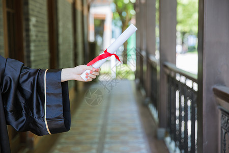 学士服毕业证教室走廊前手拿证书的毕业生背景